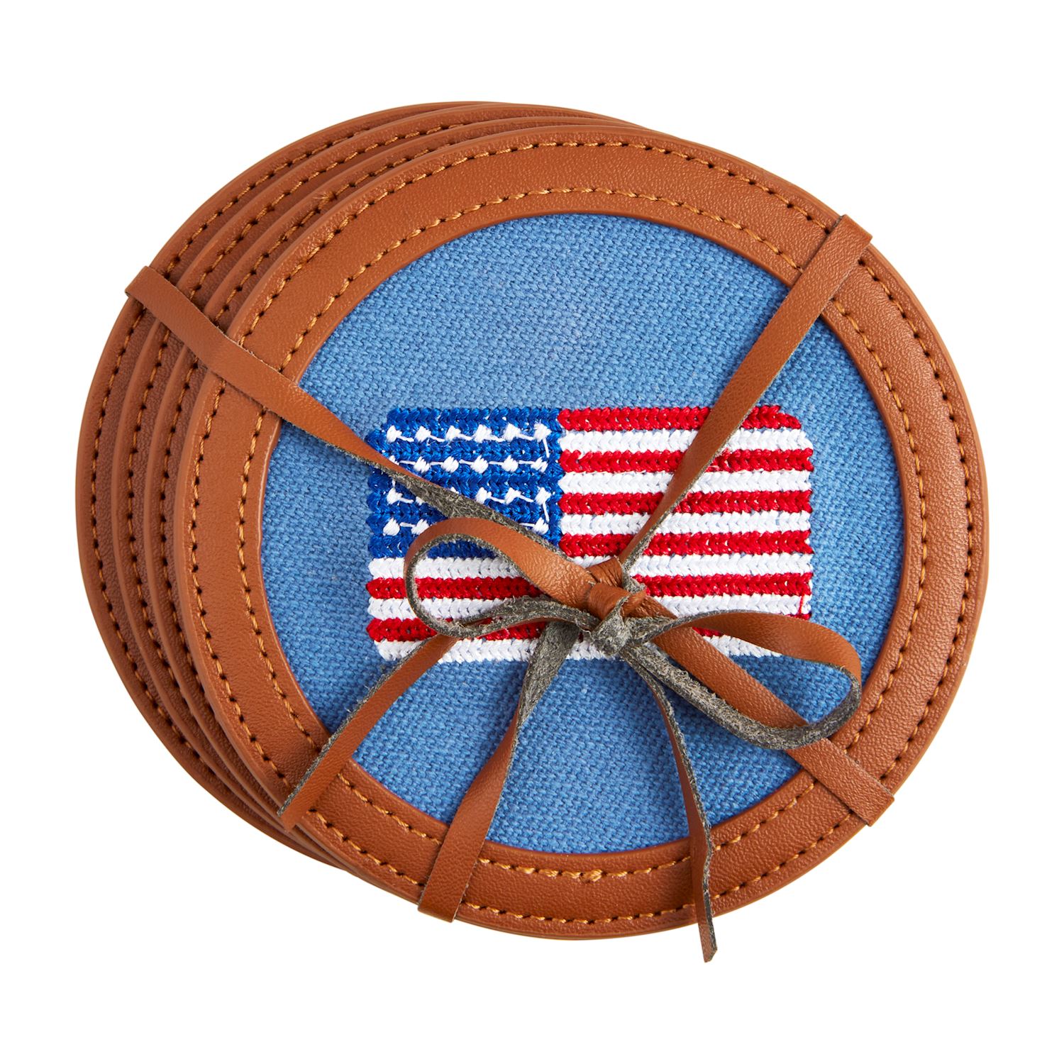 Set of four round cotton coasters with embroidered American flag design and leather trim, tied with a decorative bow.