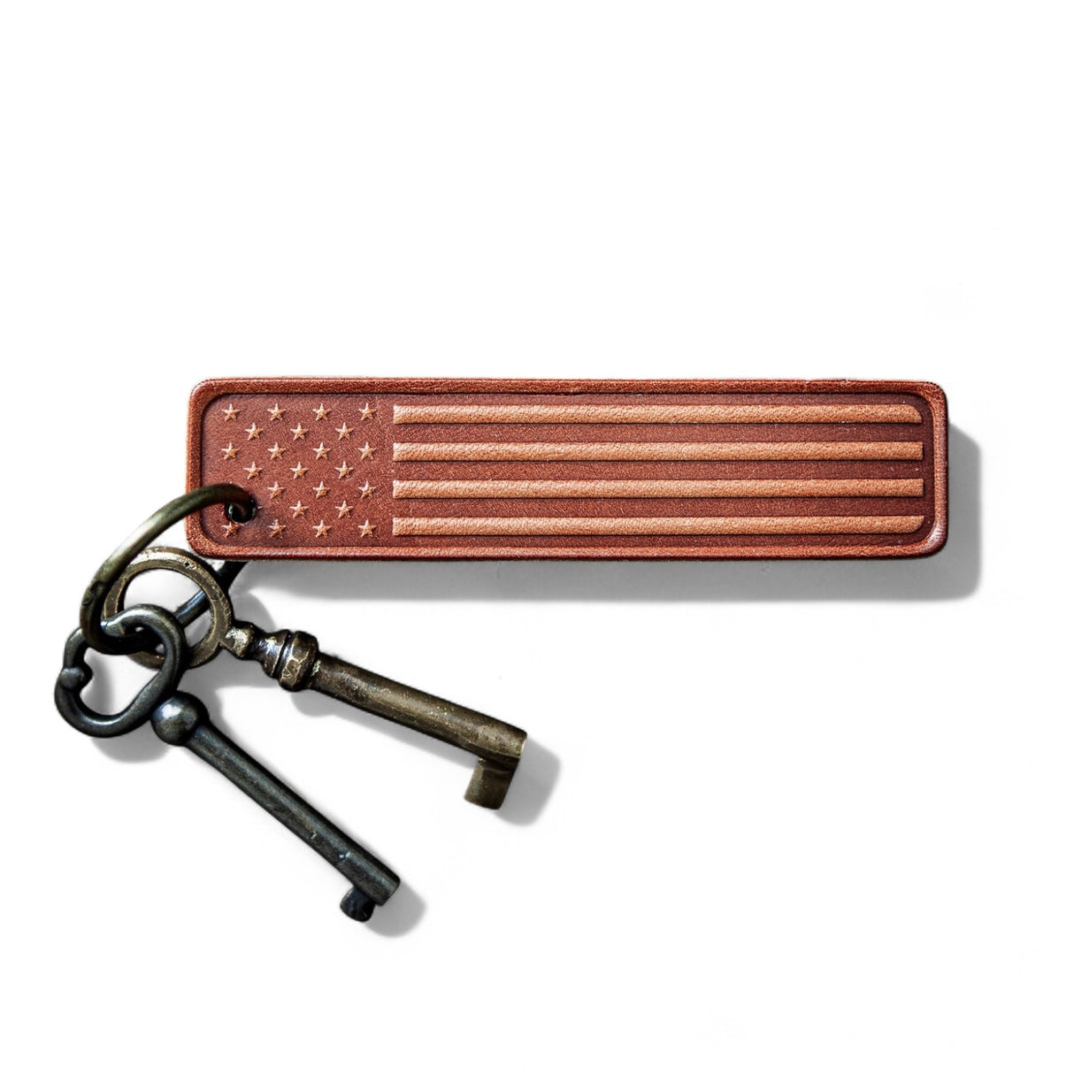 Rectangular leather keychain with embossed American flag and antique-style keys on ring