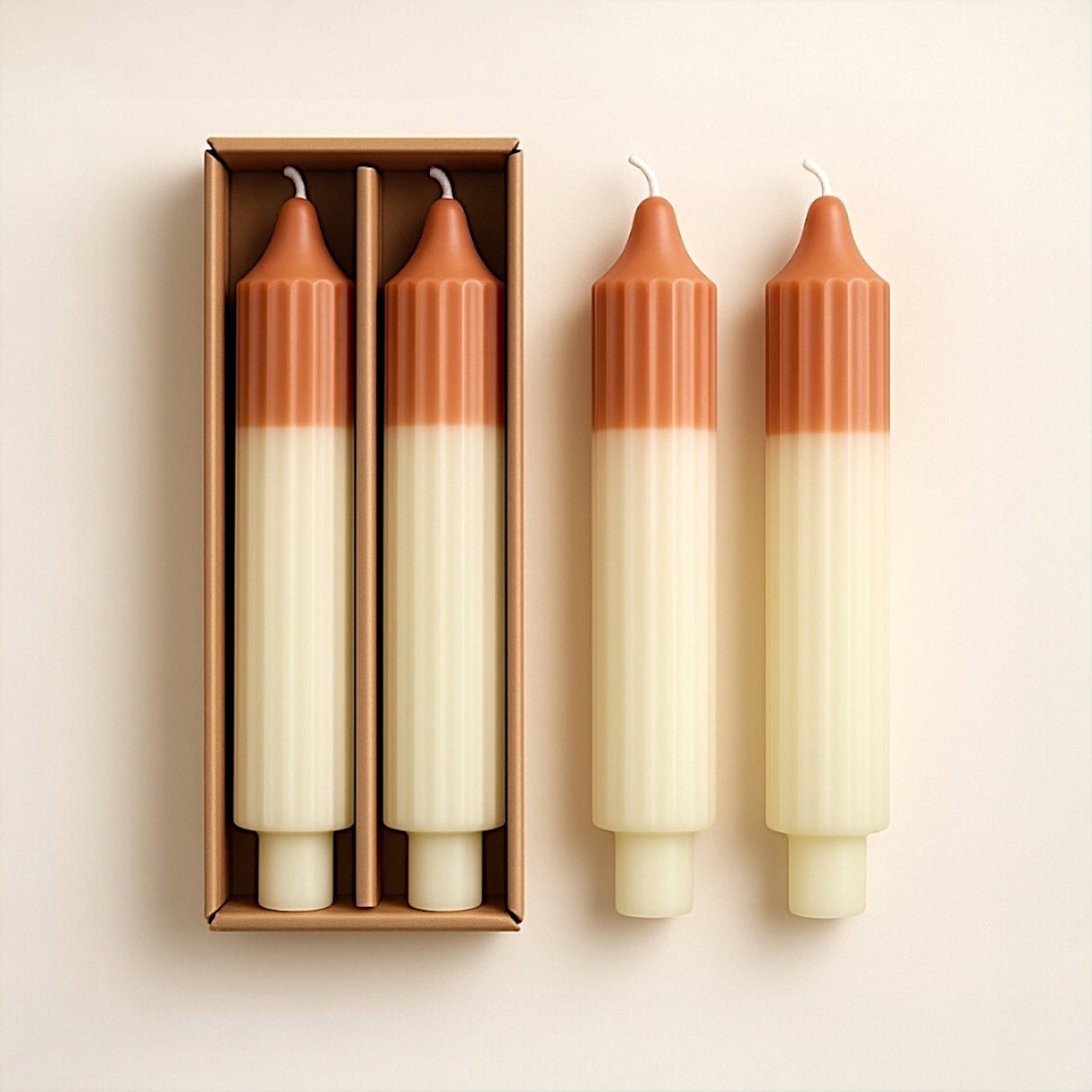 Set of two unscented, two-tone pleated taper candles in camel and mint, displayed with packaging.