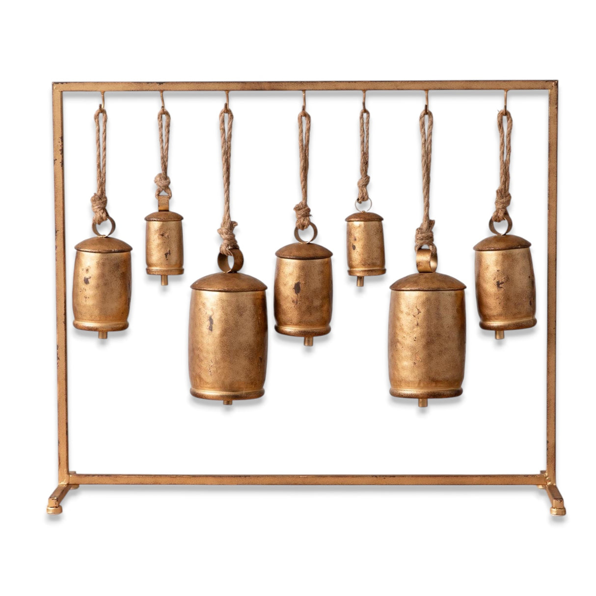 Seven distressed gold bells hanging from a metal stand with jute rope accents.