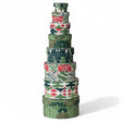 Stacked round holiday nesting gift boxes in red, green, and white patterns