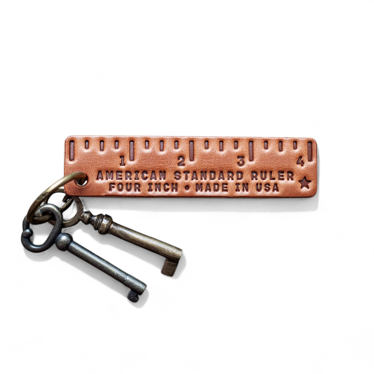 Leather pocket ruler keychain stamped with 4-inch markings and Made in USA with antique-style keys on ring