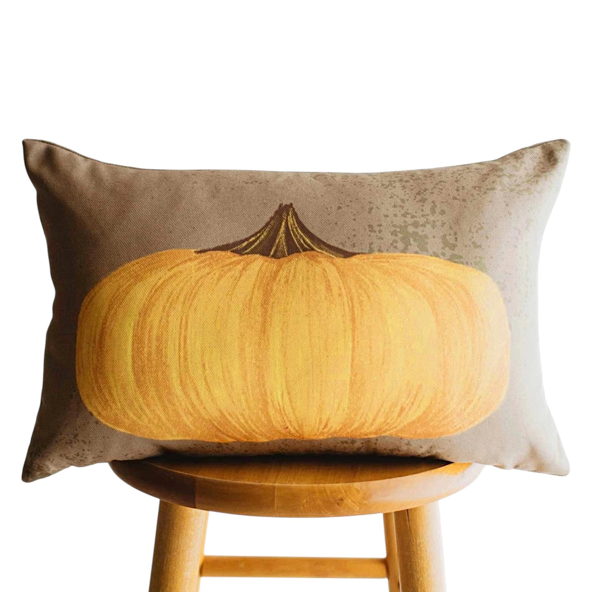 Primitive yellow pumpkin lumbar throw pillow with vintage distressed artwork on a neutral background