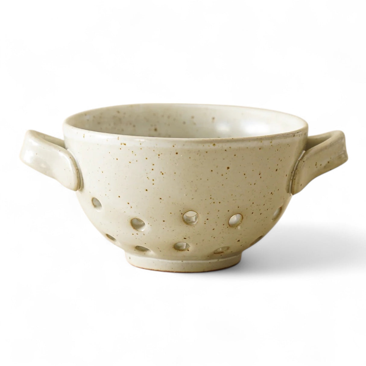 White reactive glaze stoneware berry bowl with perforated design and side handles, measuring 4.25 inches round by 2.5 inches high.