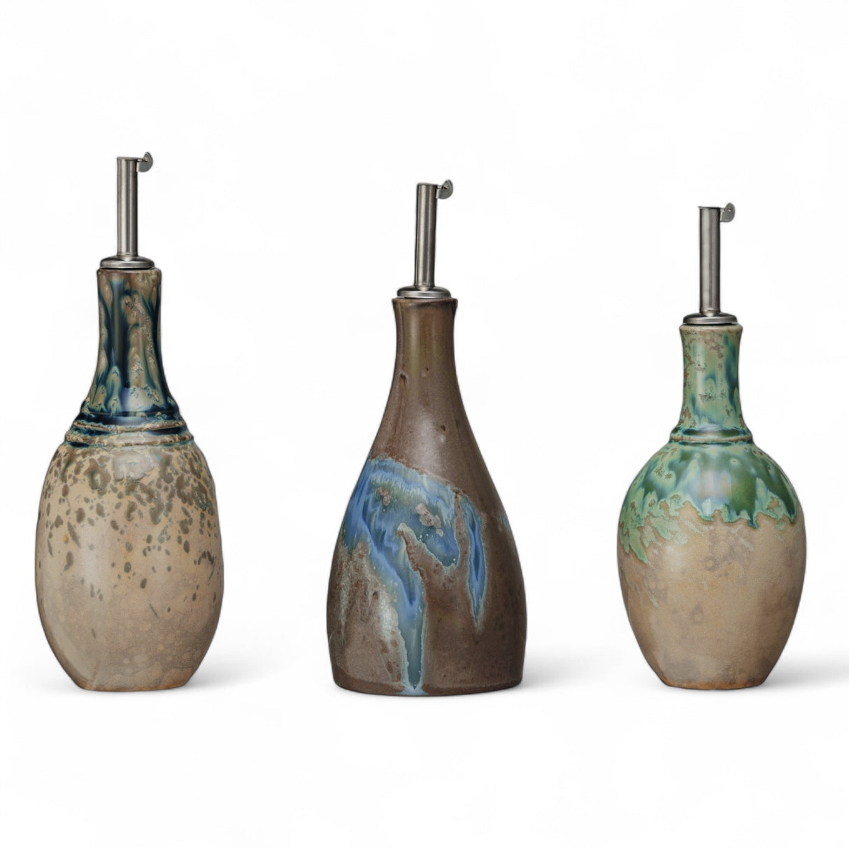 Set of 3 stoneware oil cruets with stainless steel stoppers, reactive crackle glaze finish, each 9" tall and 10 oz capacity