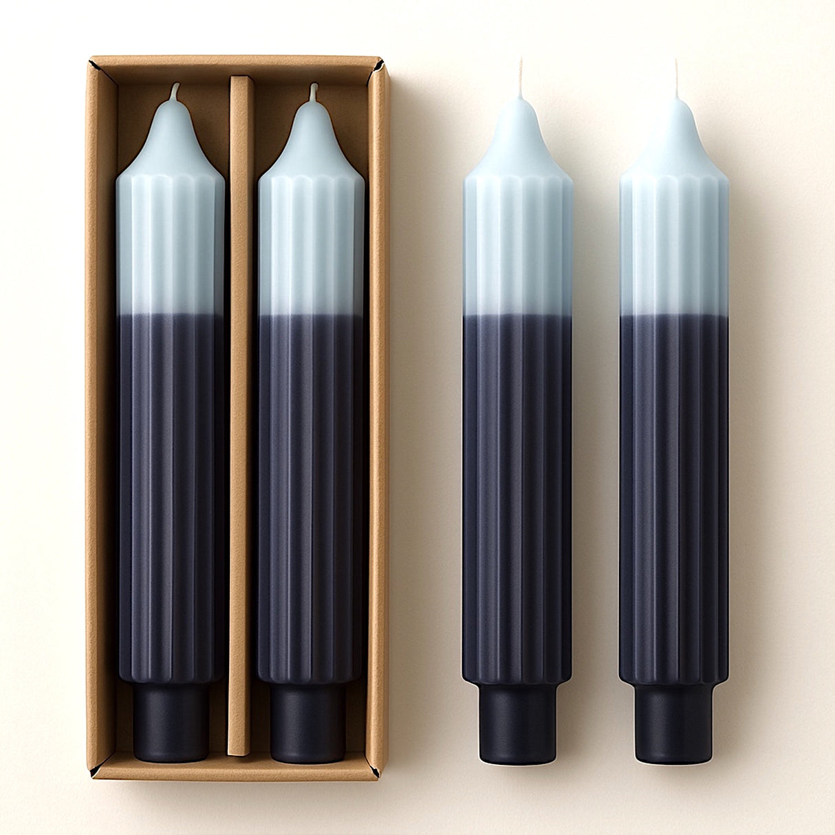 Set of two unscented, two-tone blue pleated taper candles displayed with packaging.
