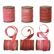 Three velvet ribbons with metallic edges on wooden spools, in varying shades of pink and red