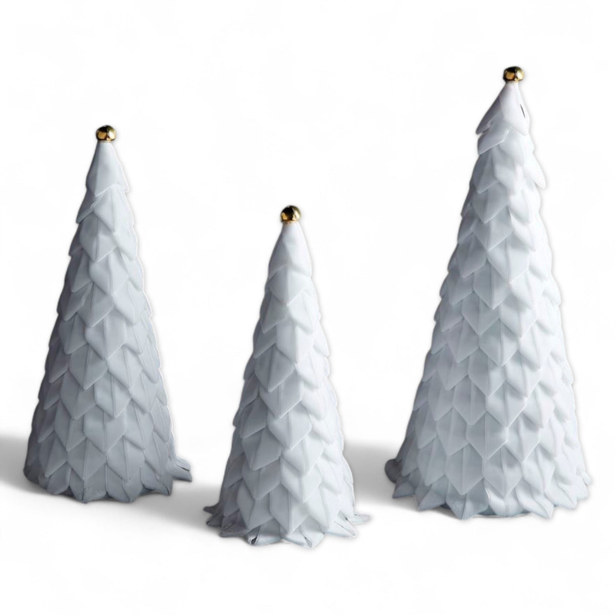 White velvet holiday trees with ribbon loops and gold jingle bell toppers, available in three sizes