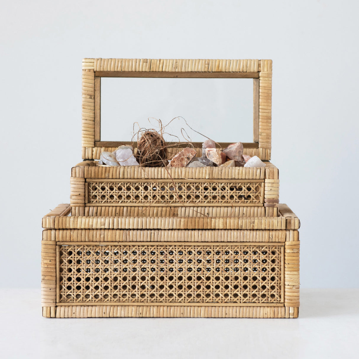 Woven rattan display boxes with glass lids in two sizes, perfect for displaying keepsakes or decor items.
