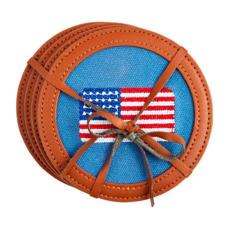 Set of four round cotton coasters with embroidered American flag design and leather trim, tied with a decorative bow.