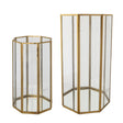 Two octagonal glass candle holders in different sizes with antique brass frames, open tops, and mirrored bottoms