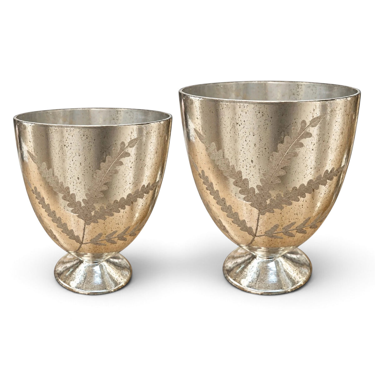 Etched mercury glass footed vases in two sizes with an antique silver finish, botanical branch patterns, and round pedestal bases