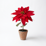 Artificial red poinsettia arrangement in a rustic cement pot for Christmas farmhouse holiday home décor.