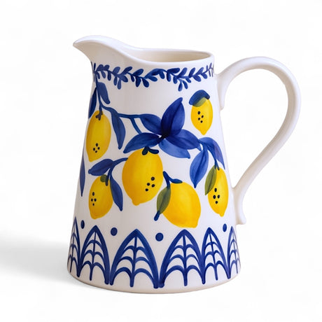 Hand-painted stoneware pitcher with lemon design in blue, white, and yellow, 1.5 quart capacity.