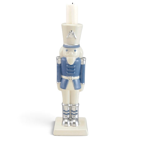 Blue and white ceramic nutcracker candleholder with silver-tone boots and accents, a square base, and a white candle atop its hat