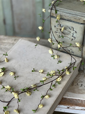 Buttercream yellow faux quince blooms garland with small rosette flowers on flexible vine, ideal for mantel and shelf styling