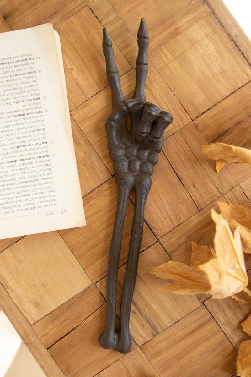 Cast iron skeleton hand sculpture holding a peace sign