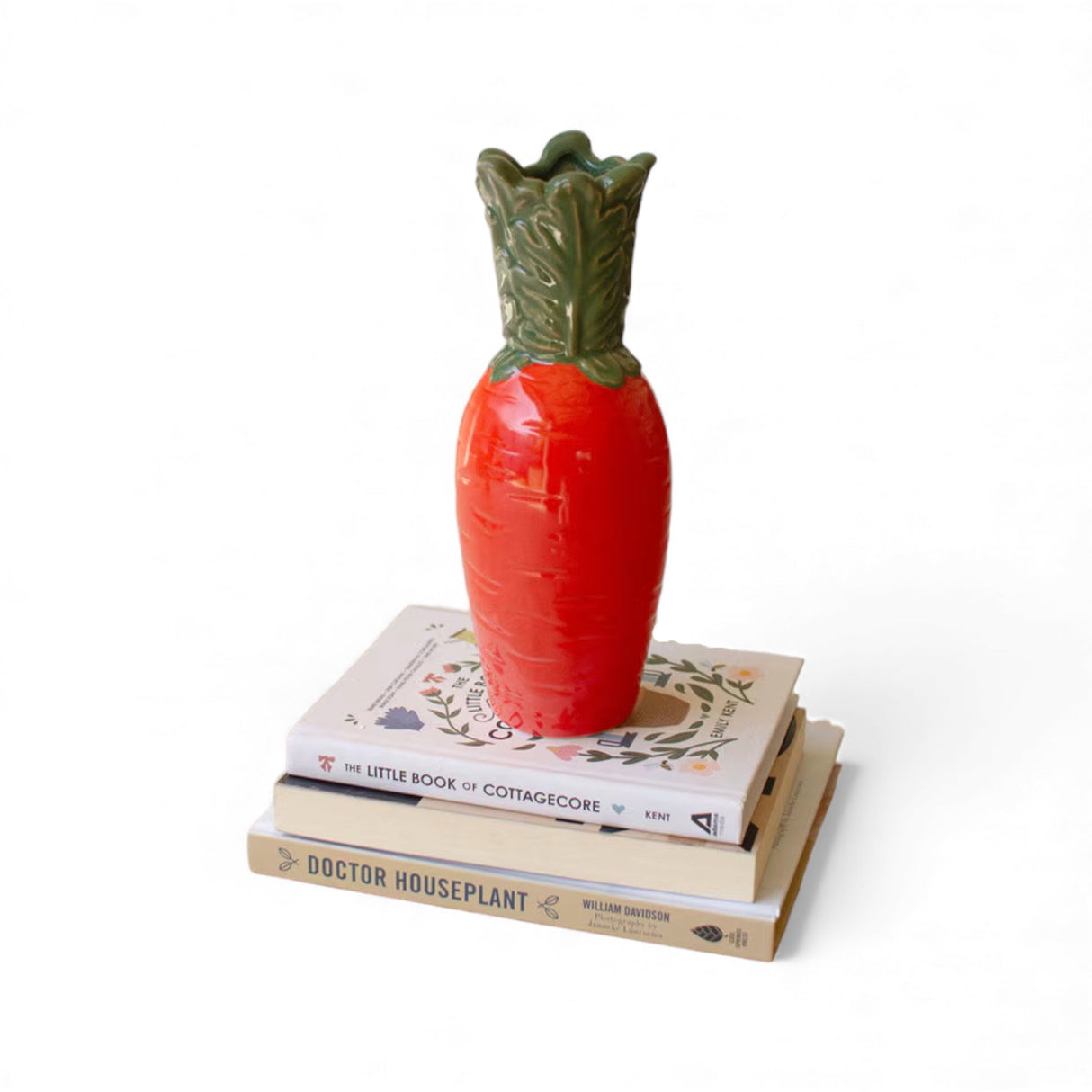 Orange ceramic carrot vase with green leaves