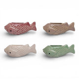 Ceramic fish vase magnet holding small flowers on refrigerator
