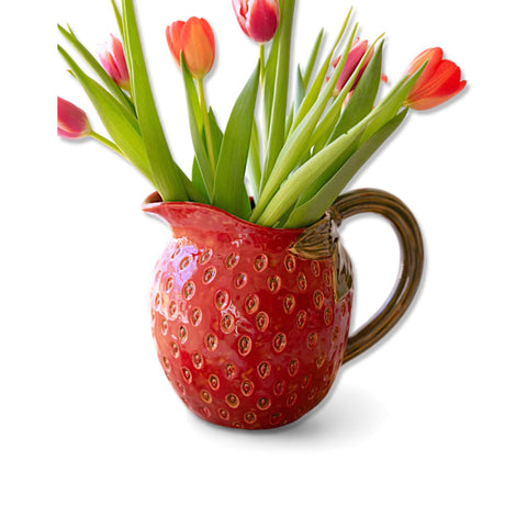 Red ceramic strawberry pitcher with green handle and leaf detailing