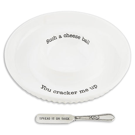 White ceramic cheese ball dish with funny text and a silver spreader that says Spread it on thick
