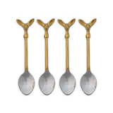  Four coffee spoons with gold-toned deer head handles and silver-toned bowls beside a cream printed drawstring bag
