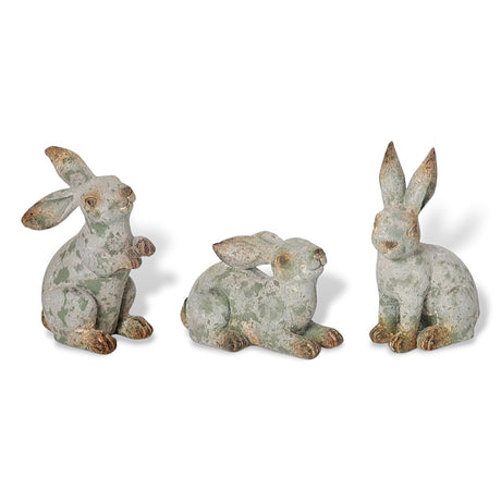 Three distressed resin rabbit figurines in different poses with a weathered finish.