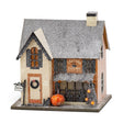 Eastside Elixirs lighted Halloween village house with glitter finish, pumpkins, storefront windows, and battery-powered interior light
