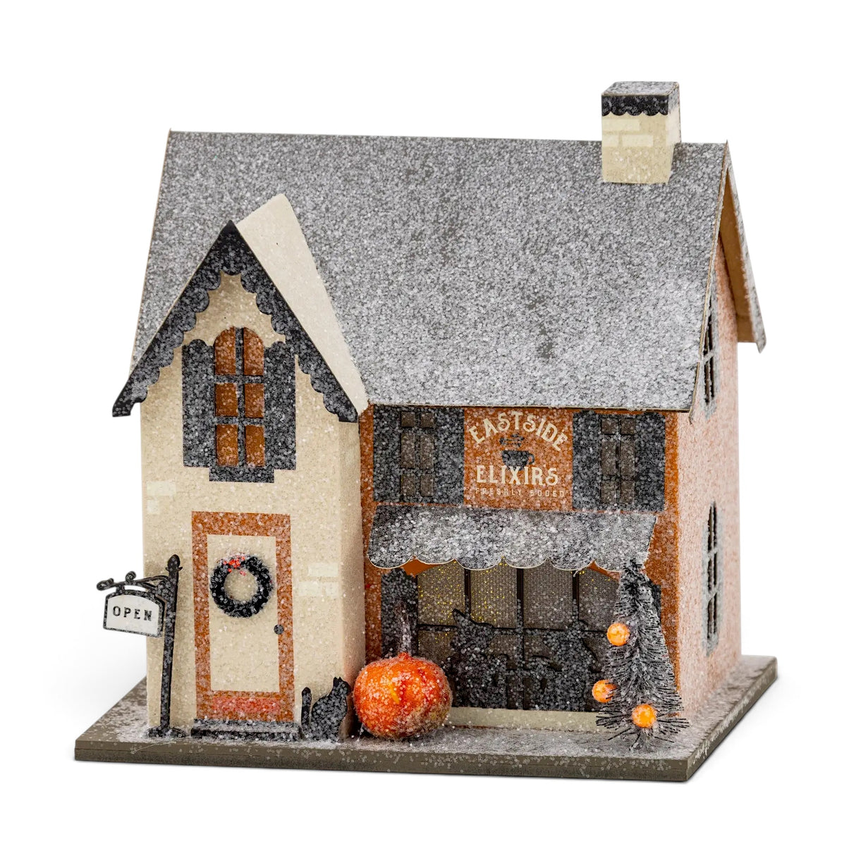 Eastside Elixirs lighted Halloween village house with glitter finish, pumpkins, storefront windows, and battery-powered interior light