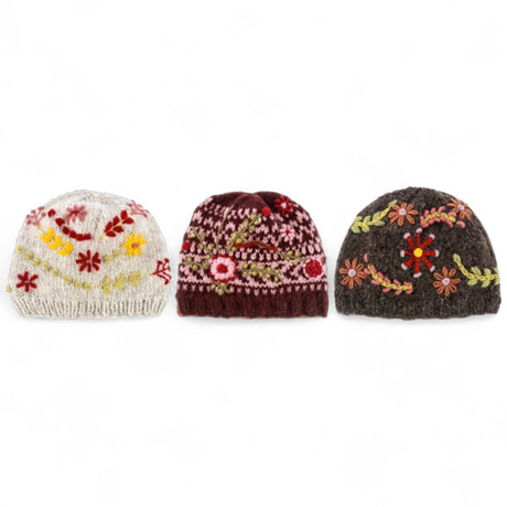 Three knit winter hats with floral embroidery in brown, cream, and burgundy styles