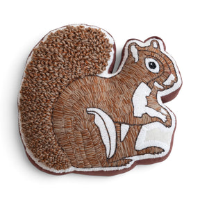 Embroidered squirrel shaped fall pillow with tufted tail and colorful woodland details
