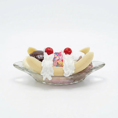 Realistic faux banana split with chocolate, vanilla and strawberry scoops in glass dish decor