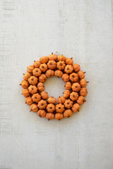 Natural dried botanical details on an orange pumpkin wreath