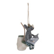 Wool felt mouse sitting on a toilet with newspaper