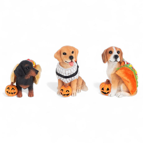 Three resin dog figurines in hotdog, sushi, and taco costumes, each with a jack-o'-lantern.