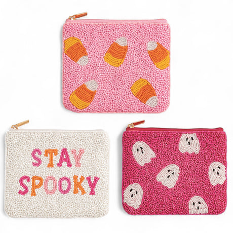 Three Halloween-themed pouches with candy corn, ghost, and 'Stay Spooky' designs on a white background.