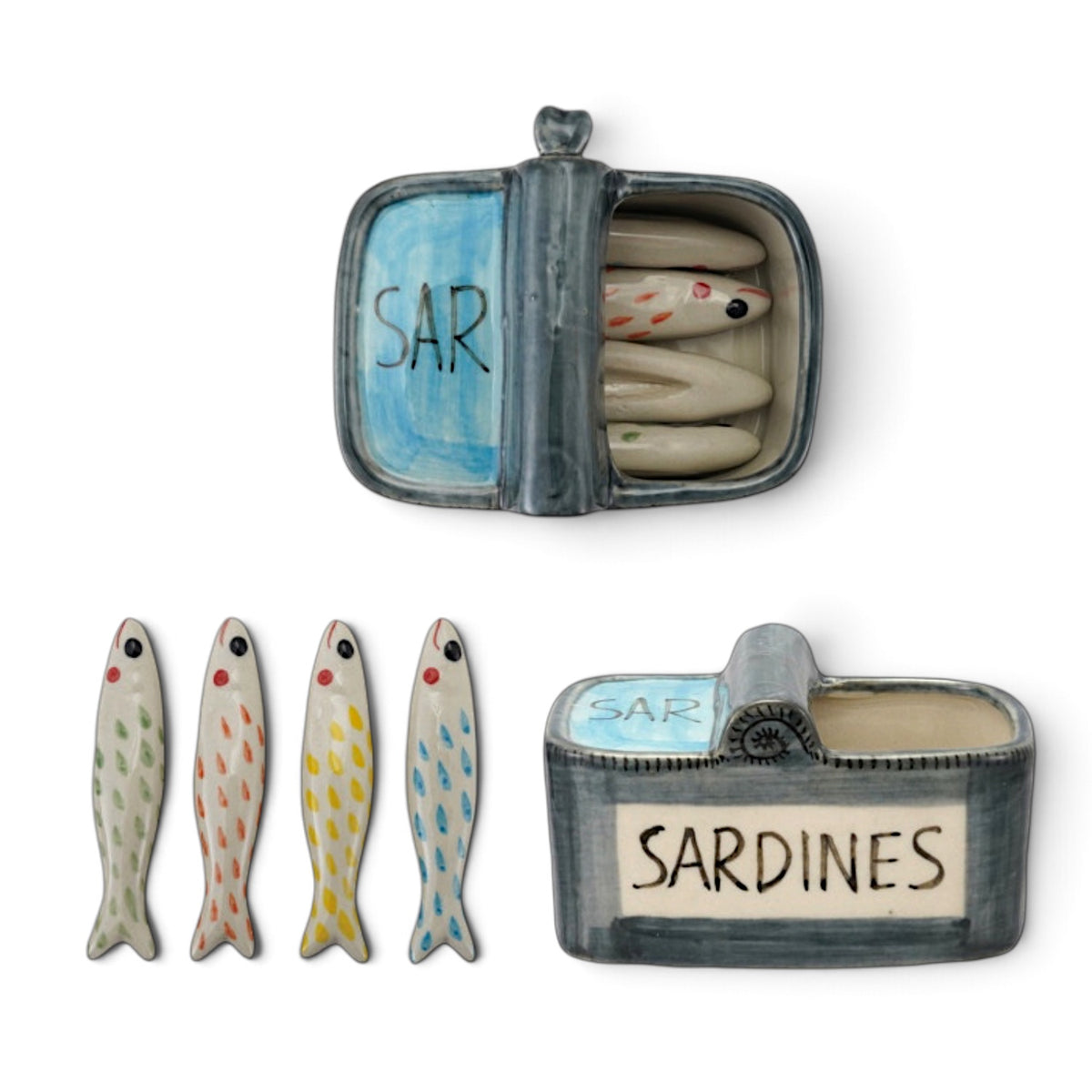Four ceramic sardine utensil rests with colorful markings beside a blue-gray sardine can shaped storage container.