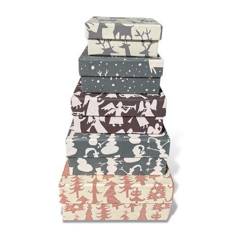 Stacked handmade holiday square gift boxes with festive recycled paper patterns