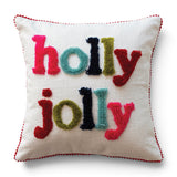 Ivory square cotton slub pillow with multicolor tufted holly jolly lettering and red pom pom trim.