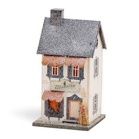 Lighted Witch Haberdashery Halloween village house with orange awnings, glitter finish, shuttered windows, and miniature broom