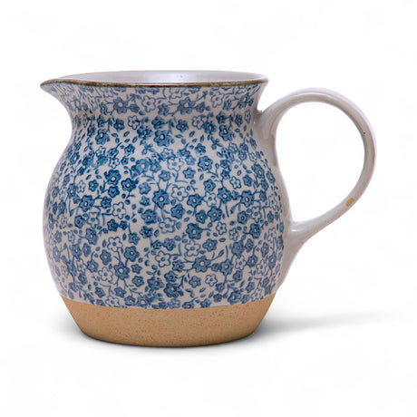 Hand-painted stoneware pitcher with blue floral pattern, 16 oz. capacity, white and blue.