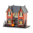 Madame Mystic lighted Halloween village house with orange glitter exterior, glowing windows, pumpkin, fencing, and 8-hour timer