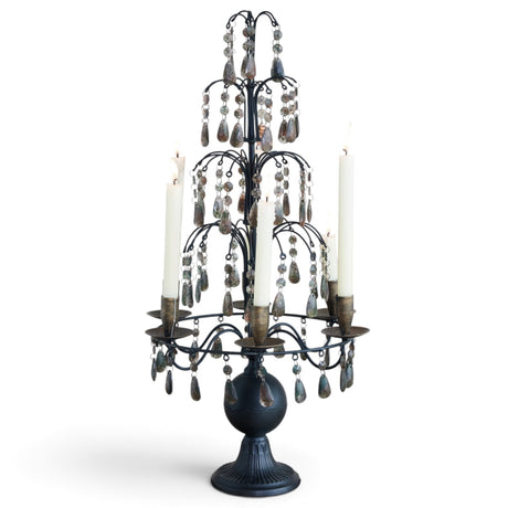 Tall matte black metal candelabra with tiered smoky acrylic crystal drops, six taper holders, and a sculpted pedestal base