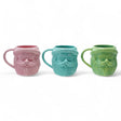 Three matte stoneware Santa head mugs in pink, blue, and green, 18-ounce capacity
