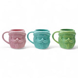 Three matte stoneware Santa head mugs in pink, blue, and green, 18-ounce capacity