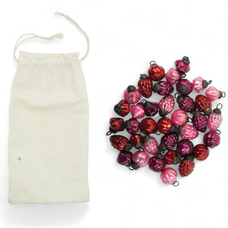 Set of 36 red, pink, and fuchsia embossed mercury glass ornaments in muslin storage bag.