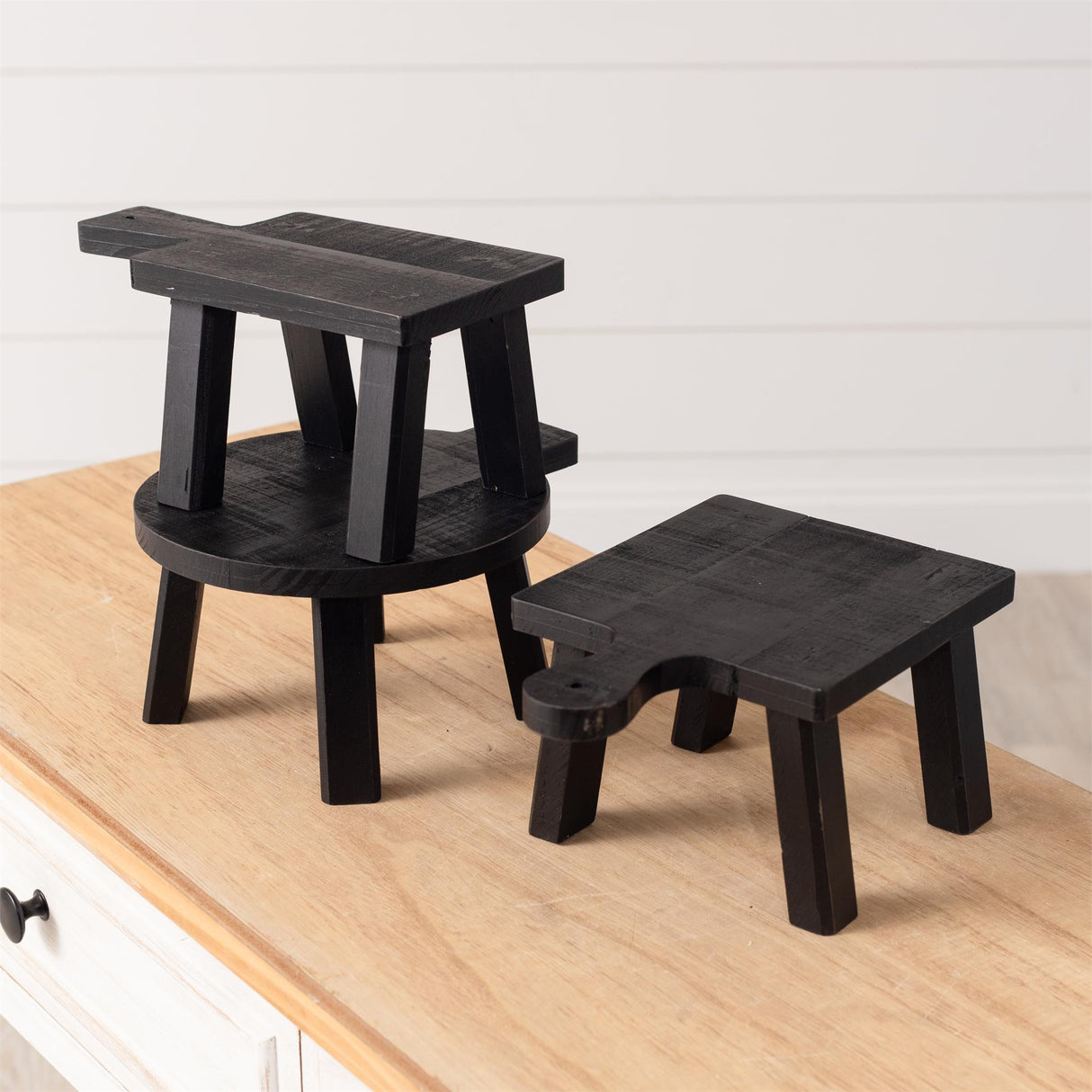 Set of three mini black wood risers in various shapes and sizes with a distressed finish