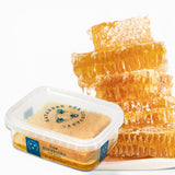 Mini raw Hungarian honeycomb in clear reusable container showing golden edible wax comb and natural honey texture made by Savannah Bee Company