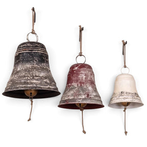 Oversized aged metal Christmas bells with rope hangers in three graduated sizes.