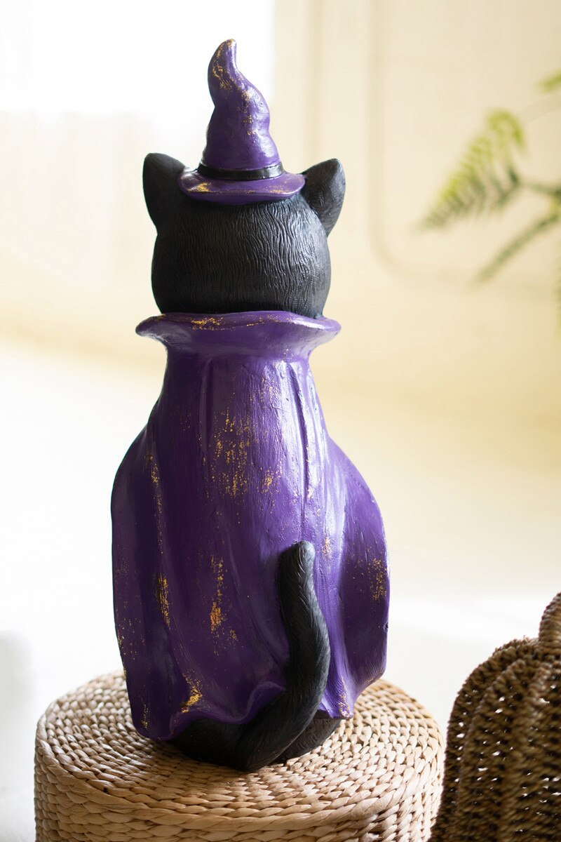 Painted black cat figurine with purple witch costume and gold leaf details